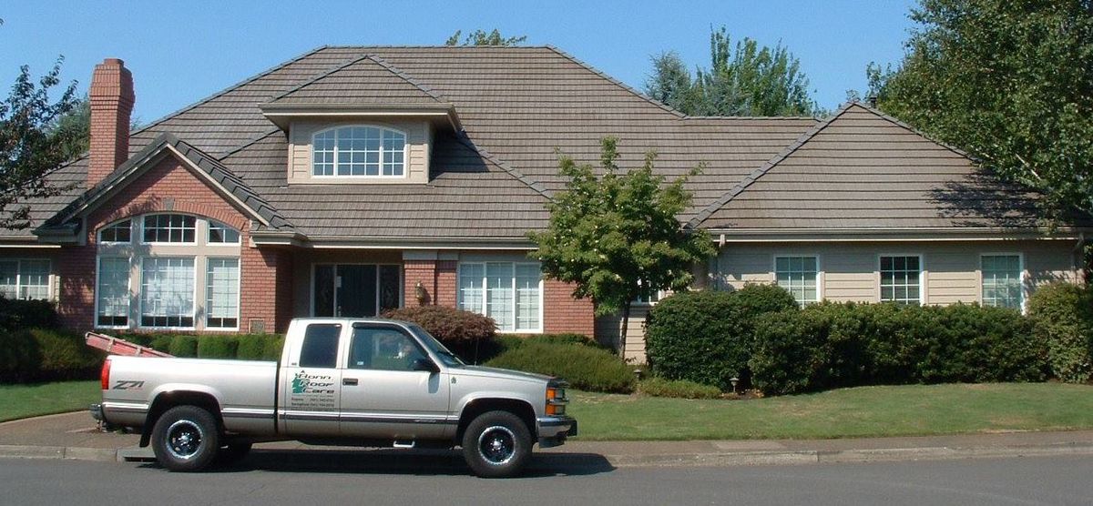 Silver pickup truck parked in front of a large suburban home with a well-maintained lawn.